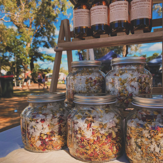 A bag of postpartum bath soak surrounded by dried flowers